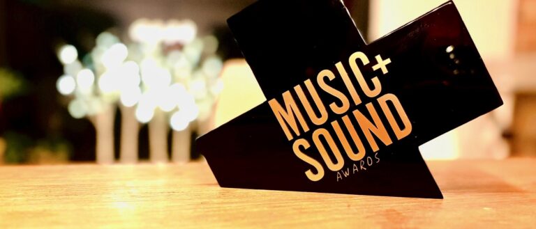 Music+Sound Awards trophy on a wooden surface.