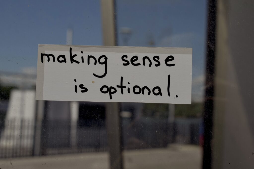 Note reading “making sense is optional” taped to a window, reflecting the arbitrary logic often behind creative awards and industry recognition