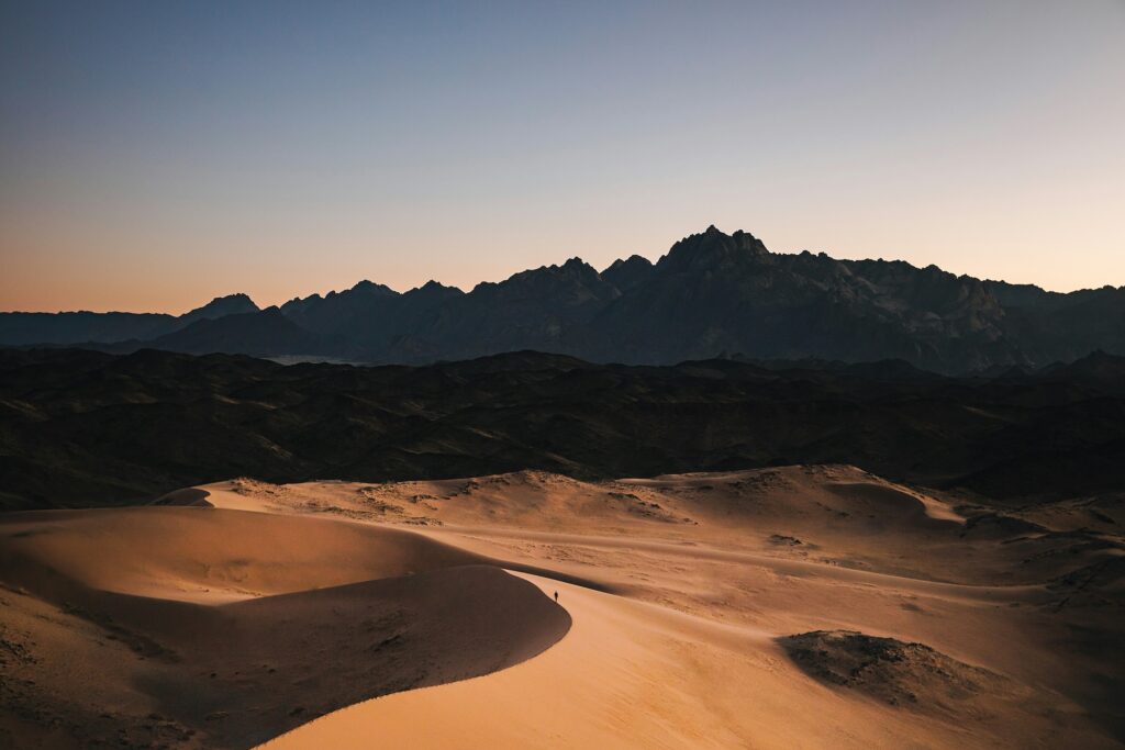 Desert landscape at sunset in NEOM with sand dunes and mountain backdrop